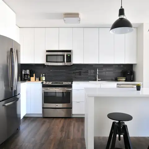 A white kitchen with steel appliances