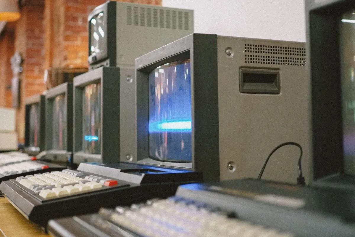 A row of vintage CRT computer monitors highlighting classic technology related to electronic disposal.