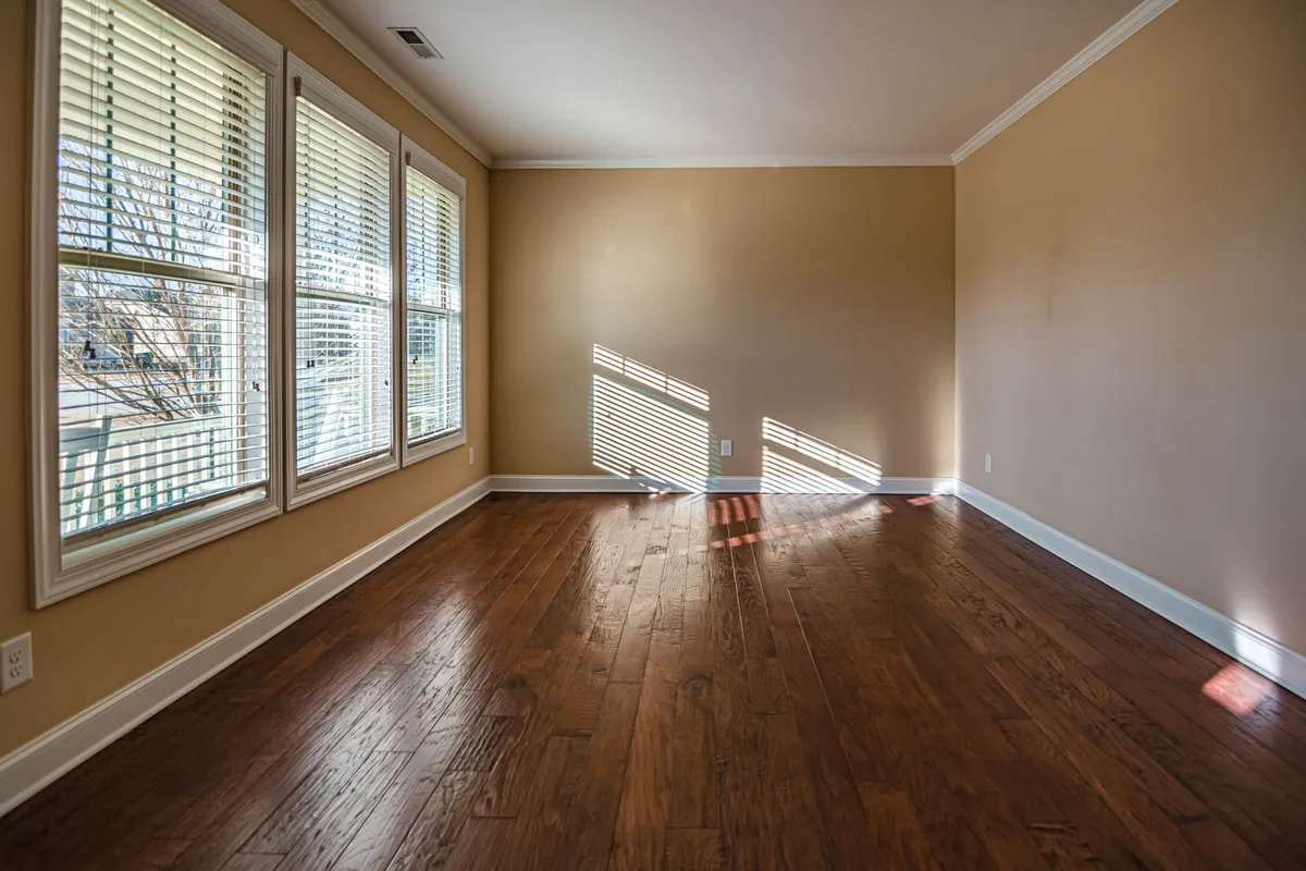 Bright empty room with hardwood floors and large windows, perfect for staging after a cleanout.